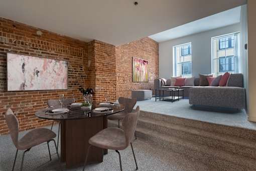 a living room with a brick wall and a table and chairs at Parkside Apartments, St. Paul, 55101