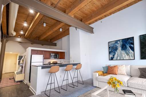 a kitchen with a bar and a living room with a couch at Parkside Apartments, St. Paul, Minnesota
