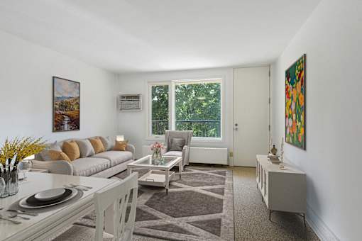 a living room with a couch and a table and a window at Humboldt Senior 55+ Apartments, Saint Paul