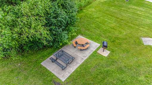 a backyard patio with a table and chairs and a fire pit at Pheasant Park Apartments, Minnesota, 55428-5401
