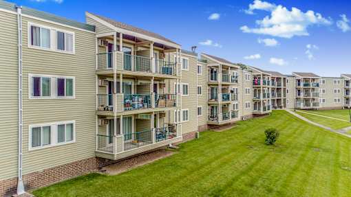 an exterior view of an apartment building with a green lawn at Pheasant Park Apartments, New Hope, MN