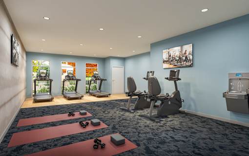 A gym with exercise equipment and yoga mats.