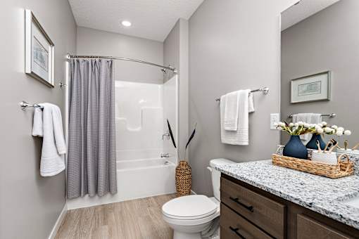 A bathroom with a toilet, sink, and shower.