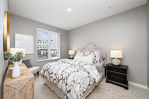 A bedroom with a large bed and a window overlooking a building.