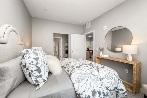 A bedroom with a large bed and a mirror on the wall.