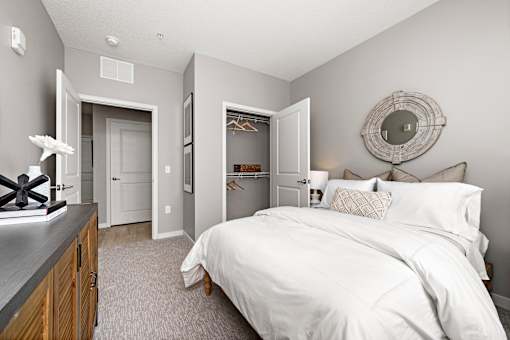 A bedroom with a large bed and a mirror on the wall.