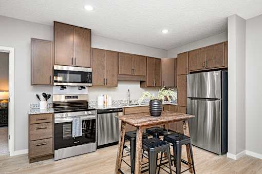 A modern kitchen with wooden cabinets and stainless steel appliances.