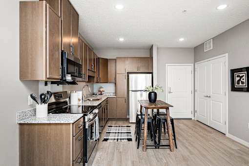 A kitchen with wooden cabinets and a black stove top oven.