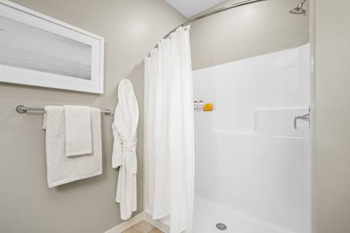 A white bathroom with a white tub and a white shower curtain.