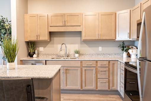 a kitchen with wooden cabinets and granite counter tops at Technology Park Apartments, Rochester