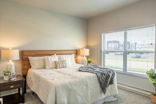 a bedroom with a bed and a large window at Technology Park Apartments, Rochester, MN, 55901