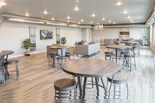 a communal area with tables and chairs in a large room at Technology Park Apartments, Rochester