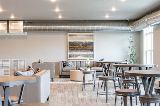 a communal area with tables and chairs in a living room at Technology Park Apartments, Rochester, MN, 55901