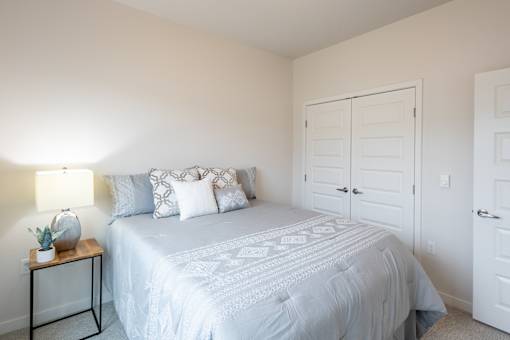 a white bedroom with a white bed and a white closet at Technology Park Apartments, Rochester, 55901