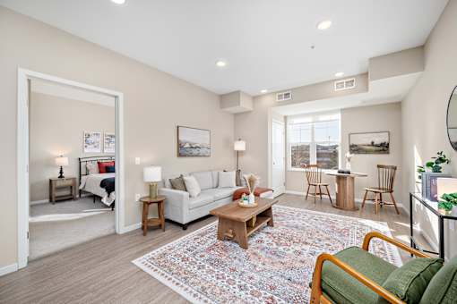 A living room with a white couch, a coffee table, and a rug at The Winslow 62+ Apartments, West St Paul, MN