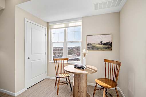A room with a table and chairs and a painting on the wall at The Winslow 62+ Apartments, West St Paul, MN, 55118