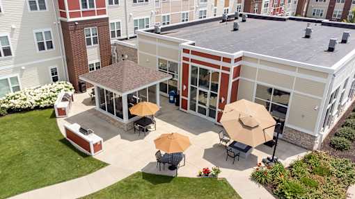 an aerial view of the courtyard of a building with tables and umbrellas at The Winslow 62+ Apartments, West St Paul, MN, 55118