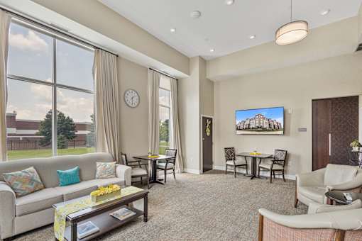 a living room with a couch and a table with chairs at The Winslow 62+ Apartments, West St Paul, 55118