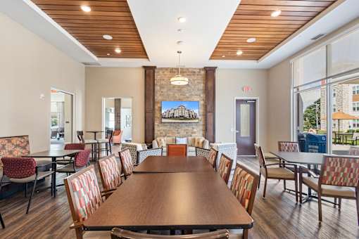 a dining room with a table and chairs and a fireplace at The Winslow 62+ Apartments, West St Paul, MN, 55118