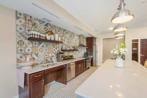 a kitchen with tiles on the wall and a white counter top at The Winslow 62+ Apartments, West St Paul, Minnesota