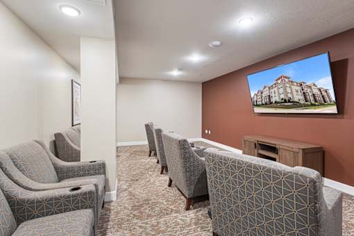a community room with couches and chairs and a tv on the wall at The Winslow 62+ Apartments, Minnesota