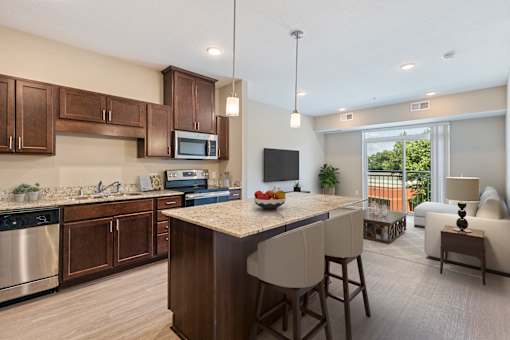 a kitchen and living room with a large island with a granite counter top at The Winslow 62+ Apartments, West St Paul, 55118