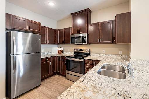 a kitchen with stainless steel appliances and marble counter tops at The Winslow 62+ Apartments, West St Paul