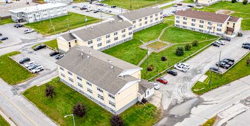 A large building complex with a parking lot in front.