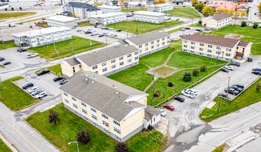 A large building complex with a parking lot in front.