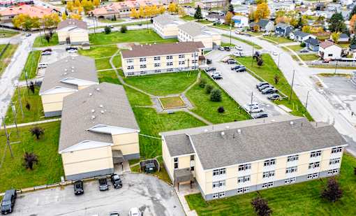 A large building complex with a parking lot in front.