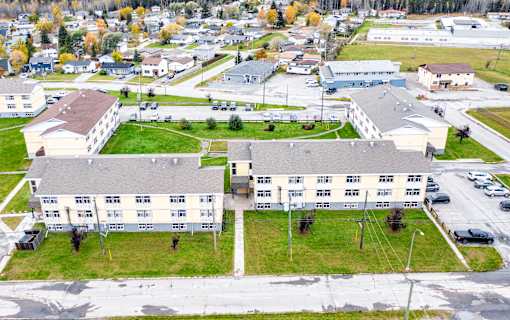 A large building complex with a parking lot in front.