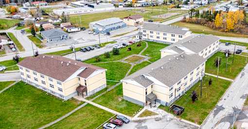 A large building complex with a parking lot in front.