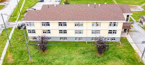 A large building with a brown roof and a green lawn in front.