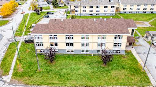 A large building with a brown roof is surrounded by a grassy area.