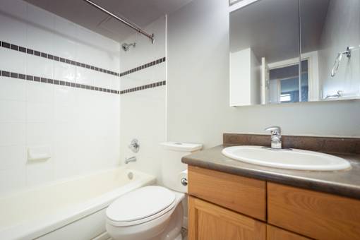A white toilet sits next to a bathtub in a bathroom.