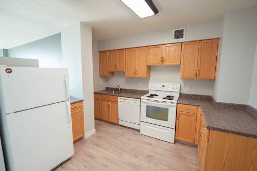 A kitchen with a white refrigerator and white stove.