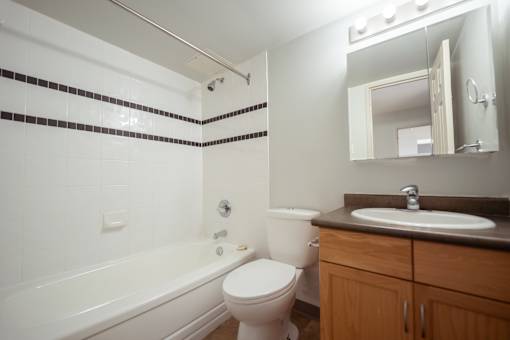 A bathroom with a white toilet, a bathtub, and a sink.