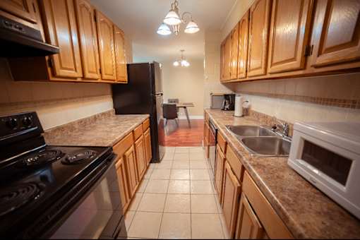 A kitchen with wooden cabinets and a black stove top oven.