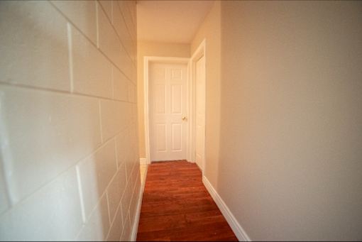 A hallway with a white door at the end.
