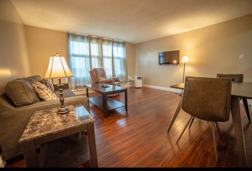 A living room with a couch, chair, and a table.