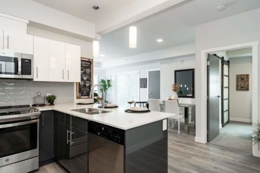 an open kitchen and living room with a large white counter top