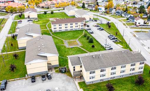 A large building complex with a parking lot in front.
