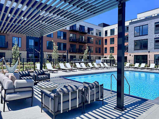 A pool area with sun loungers and a hammock.