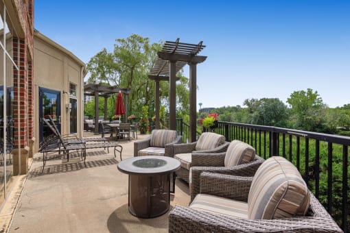 a patio with wicker furniture and a table on a balcony