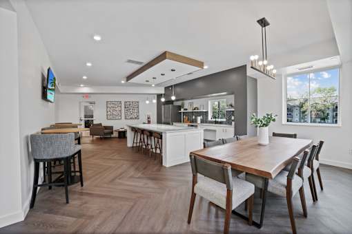 a dining area with a wooden table and chairs and a kitchen in the background at Audenn Apartments, Bloomington, Minnesota