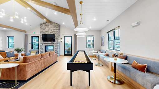 A billiard table is in the middle of a room with a couch and a fireplace.
