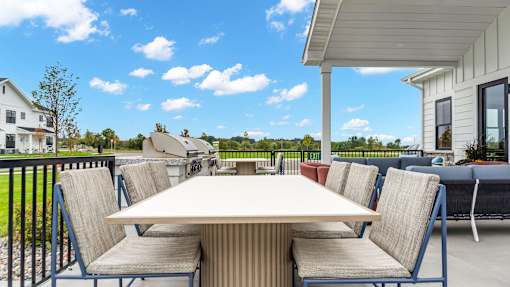 A white house with a patio table and chairs.