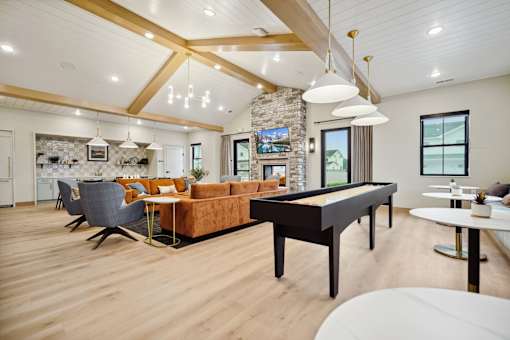 A spacious living room with a pool table and a stone fireplace.