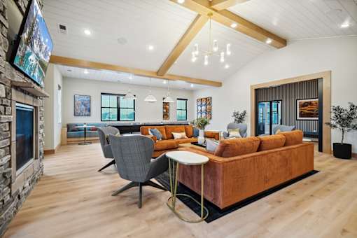 A modern living room with a stone fireplace and a large sectional sofa.