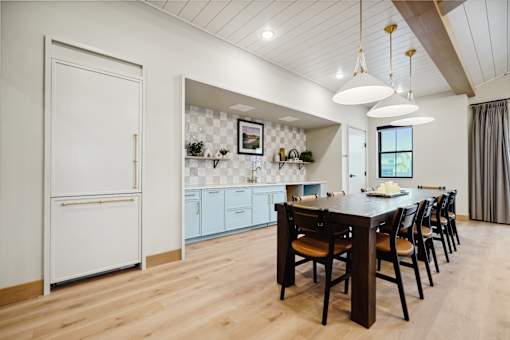 A kitchen with a table and chairs.
